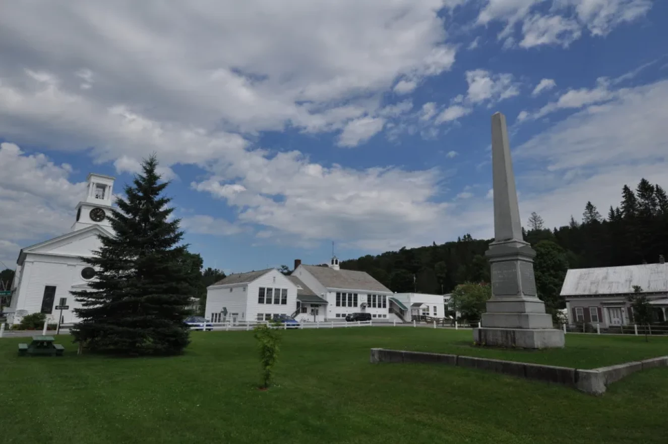 White buildings sit on green grass on a sunny day.
